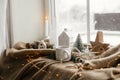 Winter hygge, Christmas still life. Warm cup of tea, christmas decor and lights at window. Cozy home