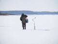 Winter ice fishing, lake, frosty day. fisherman collects gear Royalty Free Stock Photo