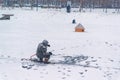 Winter ice fishing, lake, frosty day. Fisherman engaged in ice fishing in the pond of the city Park Royalty Free Stock Photo