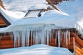 Winter icicles hanging on country house roof