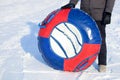 Winter inflatable tube for downhill skiing, close-up. a man holds a bright tubing