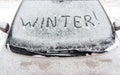 Winter inscription on the snow-covered windshield of the car