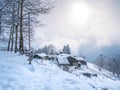 Winter in the italian Alps. Beautiful view of idyllic village in snowy forest and snowcapped mountain peaks. Piedmont, Italy Royalty Free Stock Photo