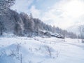 Winter in the italian Alps. Beautiful view of idyllic village in snowy forest and snowcapped mountain peaks. Piedmont, Italy Royalty Free Stock Photo