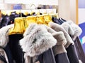 Winter jackets with grey fur collars in clothing store Royalty Free Stock Photo