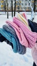 Winter knitted headbands in the hands of an unrecognizable girl. Lots of headbands in different colors. Winter. Winter