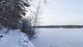 In winter, the lake is covered with ice. Along the shore there is a path with footprints in the snow. On the opposite snow-covered