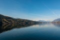 Winter lake landscape with snow covering surrounding mountains.