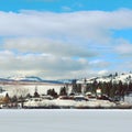 Winter lake, mountains and town Royalty Free Stock Photo