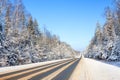 Winter landscape with asphalt road, forest and blue sky Royalty Free Stock Photo