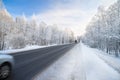 Winter landscape with asphalt road,forest and blue sky. Royalty Free Stock Photo