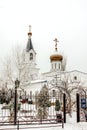 Winter landscape, a beautiful white temple with a bell tower and a golden dome and a golden cross Royalty Free Stock Photo