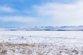 Winter landscape. Cars and cyclists on an icy road near Ogoy Island. View of the mountains and frozen Lake Baikal from above Royalty Free Stock Photo