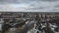 Winter landscape of the city and the river in the snow on a cloudy day. Winding river in the city park. Overcast weather.