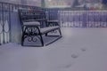 Winter landscape of the city. Tracks leading to the bench