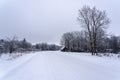 Winter landscape in the countryside - a road, a house by the side of the road Royalty Free Stock Photo