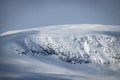 Winter landscape with dramatic cliff side on snowy mountain