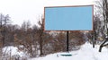 an empty billboard (template) between the road and trees Royalty Free Stock Photo