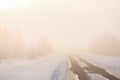 Winter landscape. Empty country road in morning fog Royalty Free Stock Photo