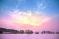 Sunset with beautiful gradient sky in the snow-covered field