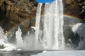 Winter landscape with famous Skogafoss waterfall with rainbow, Iceland Royalty Free Stock Photo