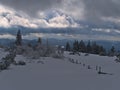 Winter landscape with fence covered by deep snow, frozen trees and panoramic view over low mountain range Black Forest. Royalty Free Stock Photo