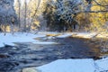 Winter landscape of a flowing river in a frosty early morning forest area. Royalty Free Stock Photo