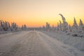 Winter landscape with forest, cliffs and sunset. Winter road. Royalty Free Stock Photo