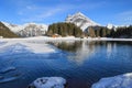 Winter landscape of the frozen Arni Lake with the snow-convered Alps peak Windgaellen