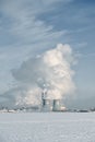 Winter landscape with frozen ice, city and pipes with thick steam