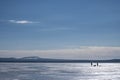 Winter landscape of frozen lake with silhouettes