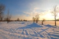 Winter landscape with frozen river covered with snow. Beautiful pink winter sunset illuminates drifts. Eco tourism Royalty Free Stock Photo