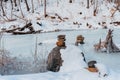 Winter landscape, a frozen river in ice in the middle of large snowdrifts of snow, unusual figures of stones stacked on top of