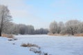 Winter landscape with frozen river and trees covered with snow Royalty Free Stock Photo