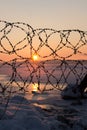 Winter landscape frozen river Volga at dusk of sunset. frozen barbed wire with icicles. Soft focus Royalty Free Stock Photo