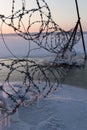 Winter landscape frozen river Volga at dusk of sunset. frozen barbed wire with icicles. Soft focus Royalty Free Stock Photo