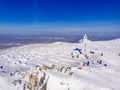 Winter Landscape of frozen worship cross mountain with blue sky Kemerovo region Russia, aerial top view