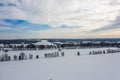 Winter landscape in Germany from a bird`s eye view, with snow-covered fields, leafless trees and wind turbines