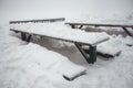 Winter landscape - a green table and benches in the snow Royalty Free Stock Photo