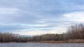 Winter landscape ice-covered lake and trees. Beautiful cloudy sk Royalty Free Stock Photo