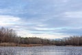 Winter landscape ice-covered lake and trees. Beautiful cloudy sky Royalty Free Stock Photo