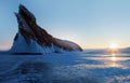 Winter landscape on Lake Baikal. Rays of the rising sun against the backdrop of a huge rock. Royalty Free Stock Photo