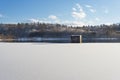 Winter landscape, lake with a dam in the foreground, against the forest and blue cloudy sky, beautiful nature, Western Ukraine Royalty Free Stock Photo