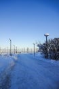 Winter landscape with a lot of snow. Walkway at Reidi tee street promenade. Blue clear sky, trees and lamp posts