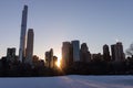 Winter Landscape and Midtown Manhattan Skyline along the Snow Covered Sheep Meadow at Central Park in New York City during a Sunse Royalty Free Stock Photo