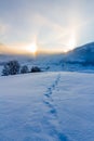 Snowy winter landscape in the alps, sunrise with halo phenomena