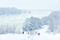 Winter landscape, Moscow, Russia. People walk in snowy park by frozen Moskva River during snowfall Royalty Free Stock Photo