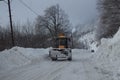 Winter landscape mountains, snow cleaning machine. Wheel loader machine, unloading snow during municipal works crews. Tractor load Royalty Free Stock Photo