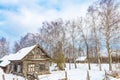 Winter landscape with old wooden house and trees with blue cloudy sky. Amazing winter scene