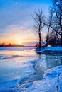 winter landscape panorama; sunset on the bank of a frozen river; ice and snow Royalty Free Stock Photo